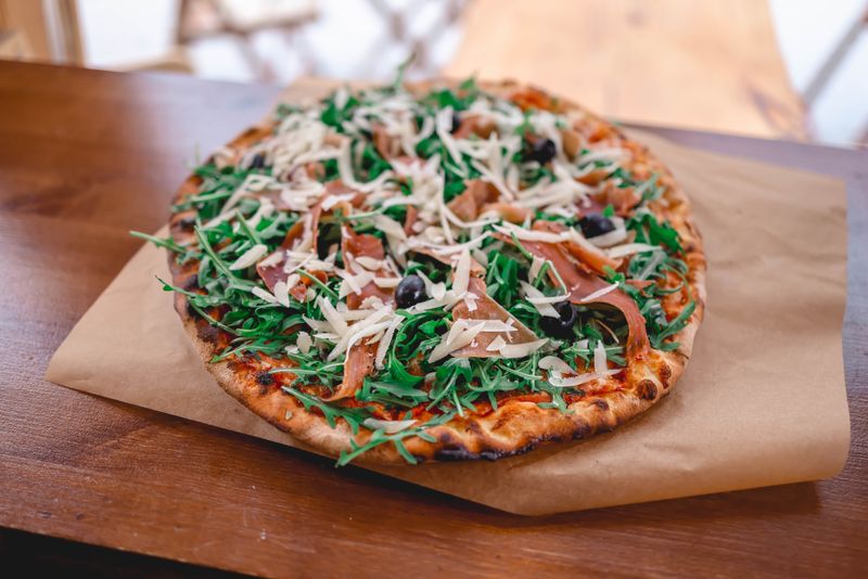 Prosciutto and arugula pizza at pizza factory